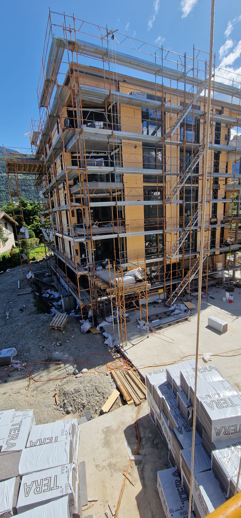 Chantier de façade avec échafaudages et matériaux