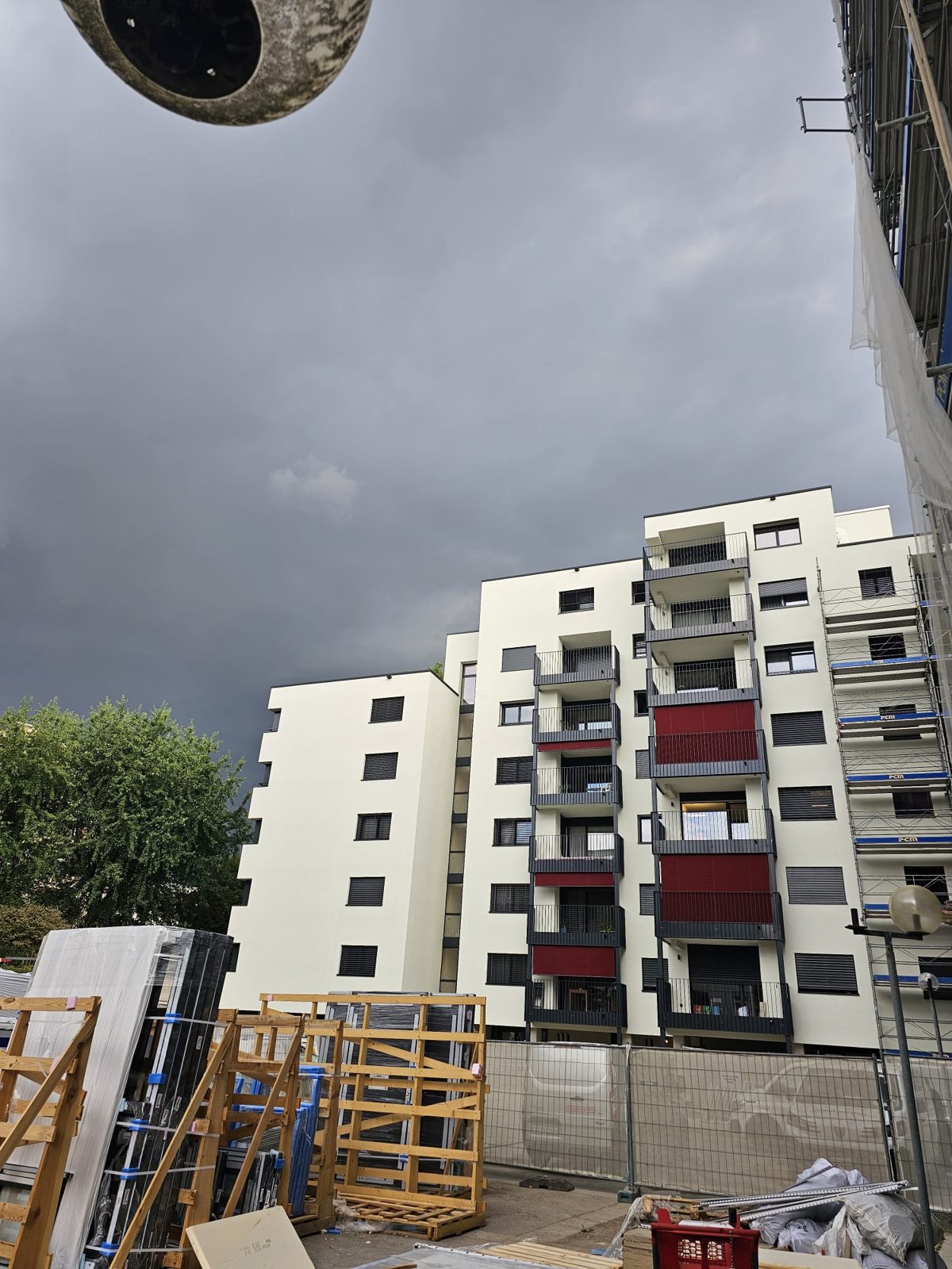 Immeuble aux balcons rouges vu depuis le chantier