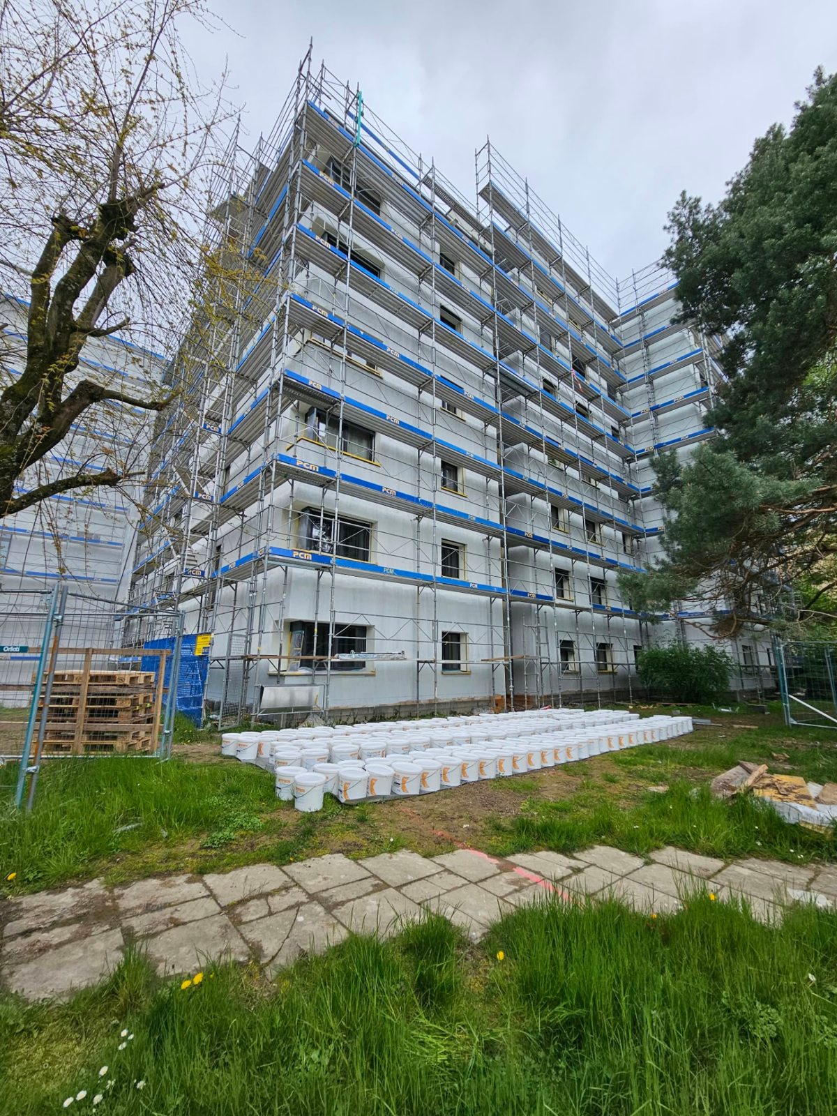 Immeuble échafaudé derrière un espace vert