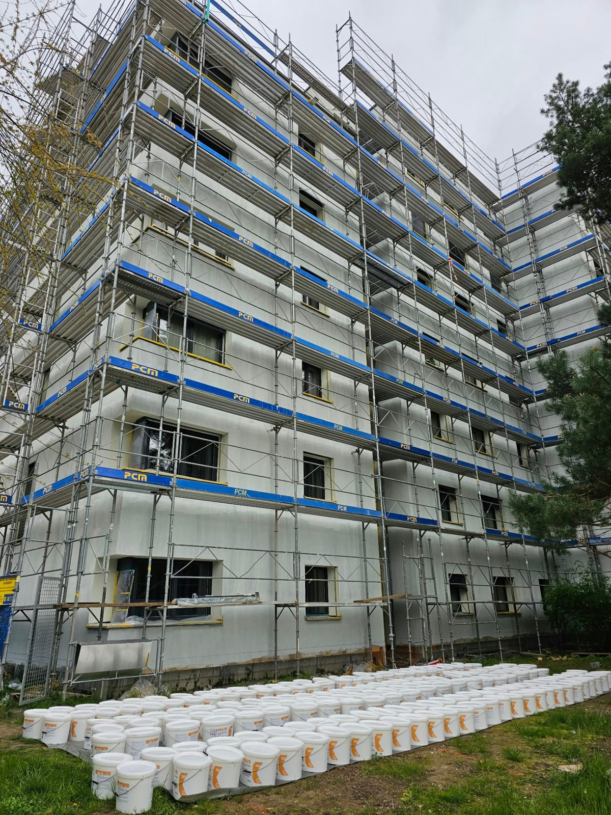 Façade échafaudée vue entre les arbres